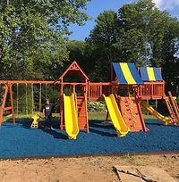 A playground with swings , slides , and a climbing wall.