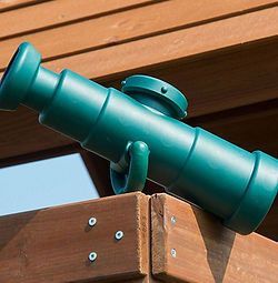A green cannon is sitting on top of a wooden structure.
