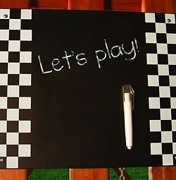 A blackboard with a pen and the words `` let 's play '' written on it.