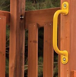 A yellow handle is attached to a wooden fence.