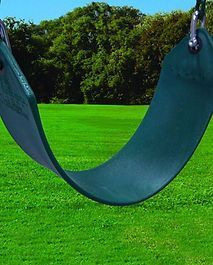 A green rubber swing is hanging in a grassy field.