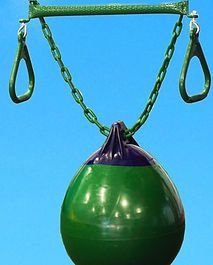 A green ball is hanging from a green chain against a blue sky.