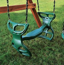 A couple of green swings sitting on top of a lush green field.