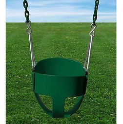 A green baby swing is hanging from chains in a grassy field.