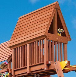 A little girl is playing on a wooden playground with a wooden roof.