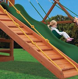 A little girl is riding a swing on a wooden slide.