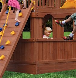 A group of children are playing on a wooden playground.