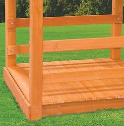 A wooden structure is sitting on top of a lush green field.