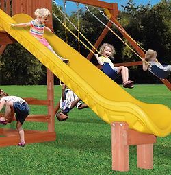 A group of children are playing on a slide and swing set.