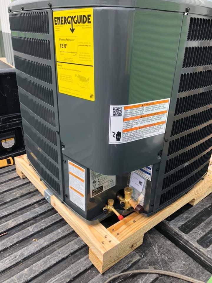 Gray commercial HVAC unit on a wooden pallet, with yellow EnergyGuide label and copper piping visible.
