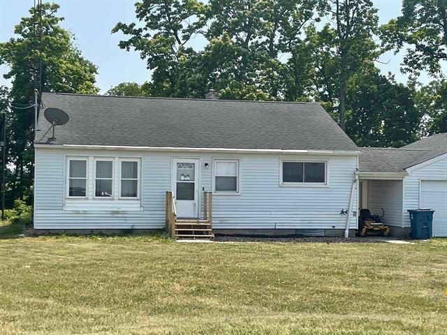 A small white house with a satellite dish on the roof