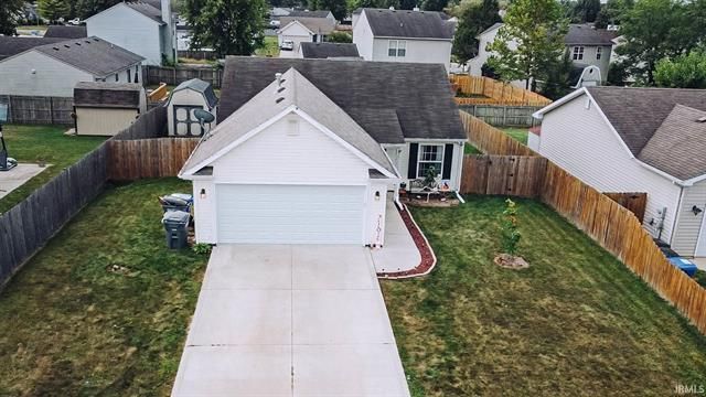 An aerial view of a house with a large driveway leading to it