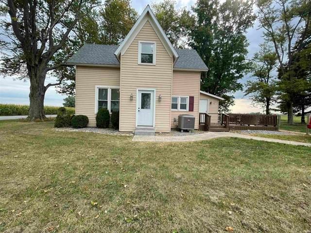 A small house is sitting on top of a lush green field