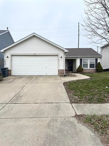 A white house with a large garage and a concrete driveway