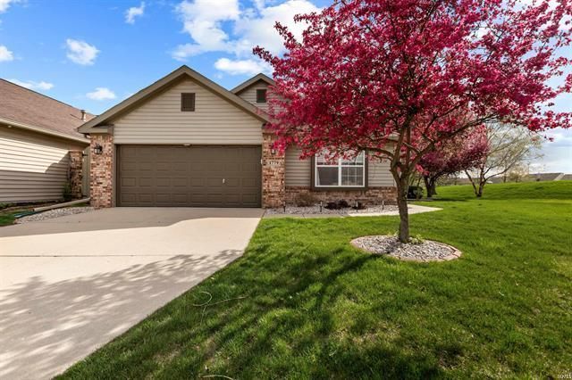 A house with a garage and a tree in front of it