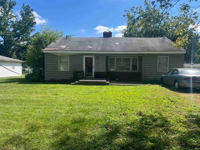 A small house with a car parked in front of it