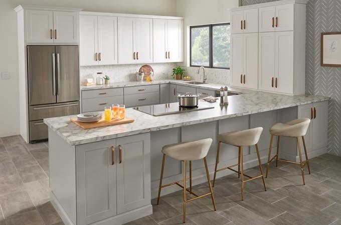 A kitchen with white cabinets , granite counter tops , stainless steel appliances and a large island.