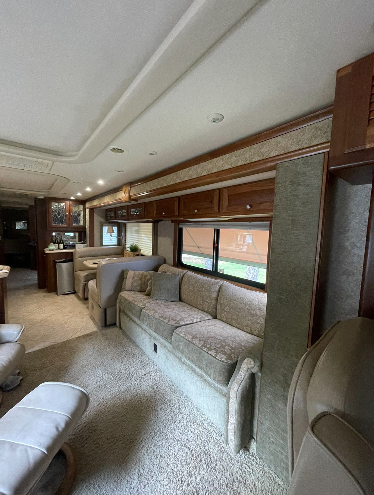 A living room in a rv with a couch and chairs.