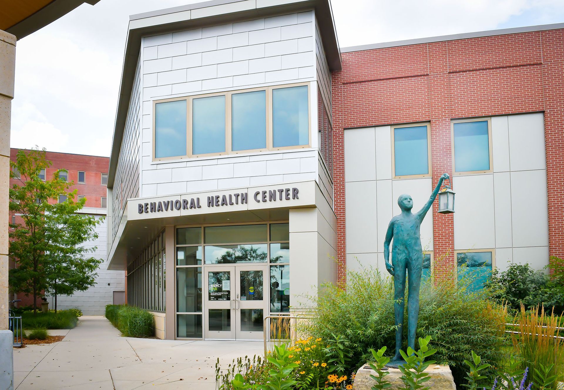 A statue of a man is in front of a building that says Birmingham health center