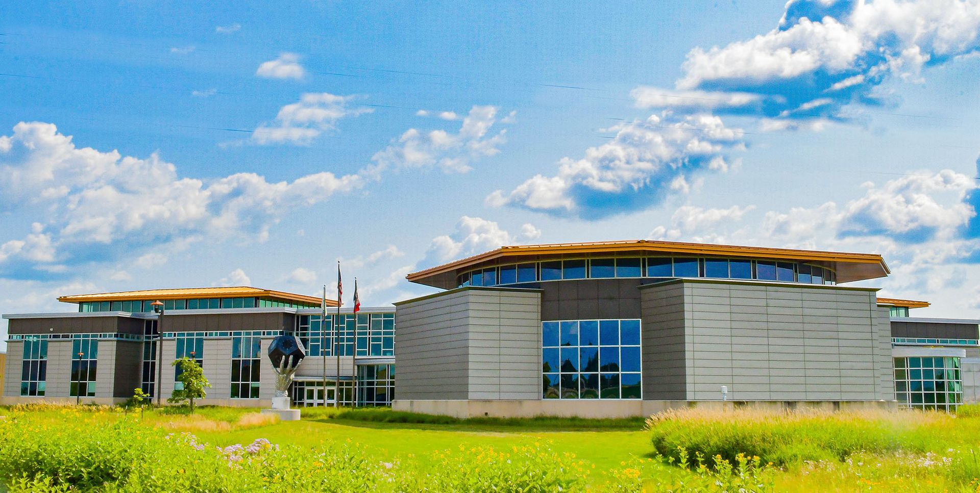 A large building is sitting in the middle of a grassy field.