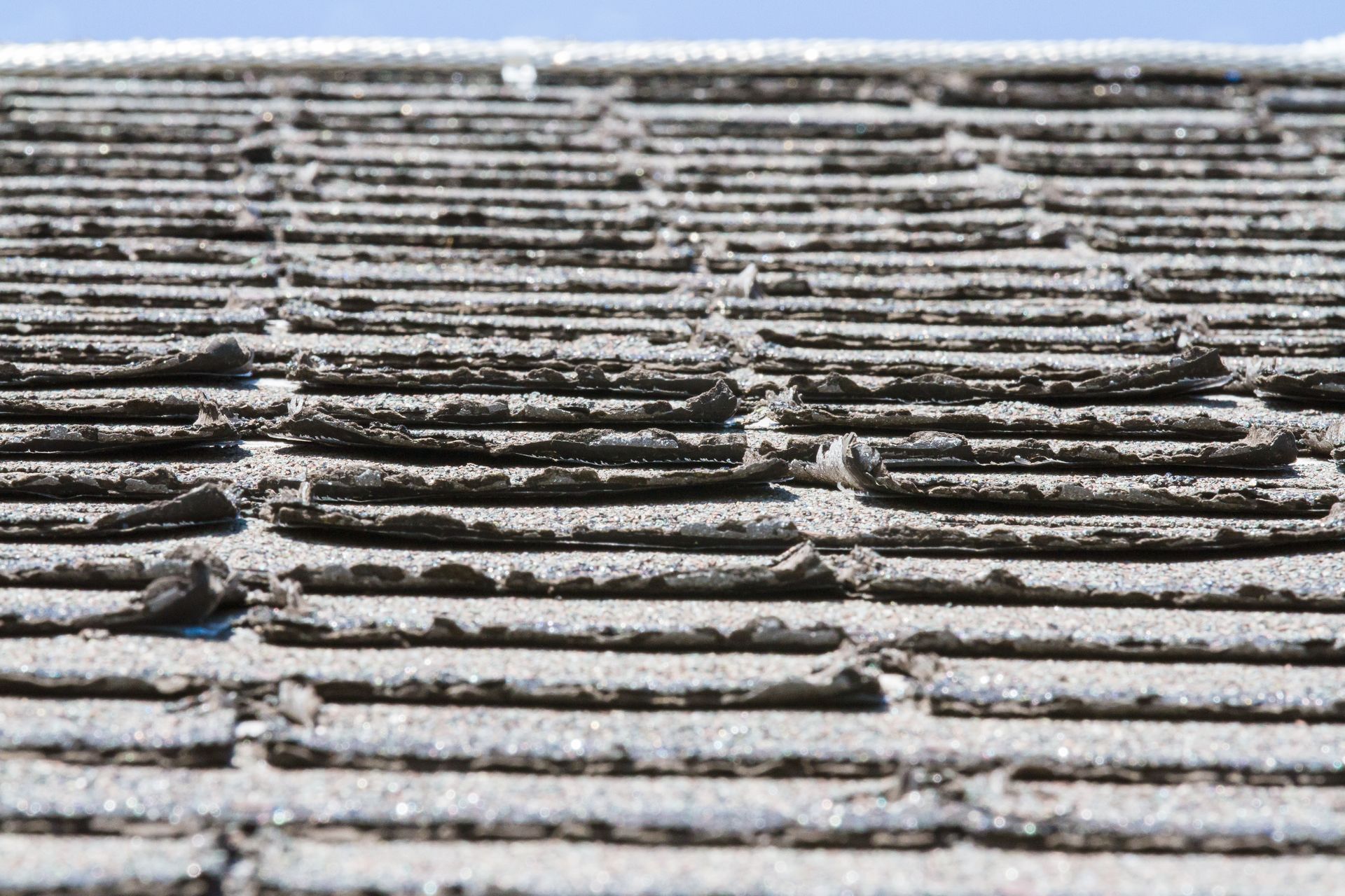 Close-up view of a deteriorating asphalt shingle roof.