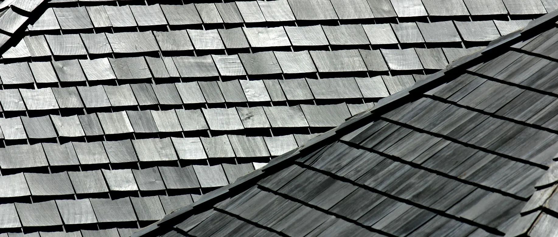 Close-up of weathered gray wooden shingles on a roof.