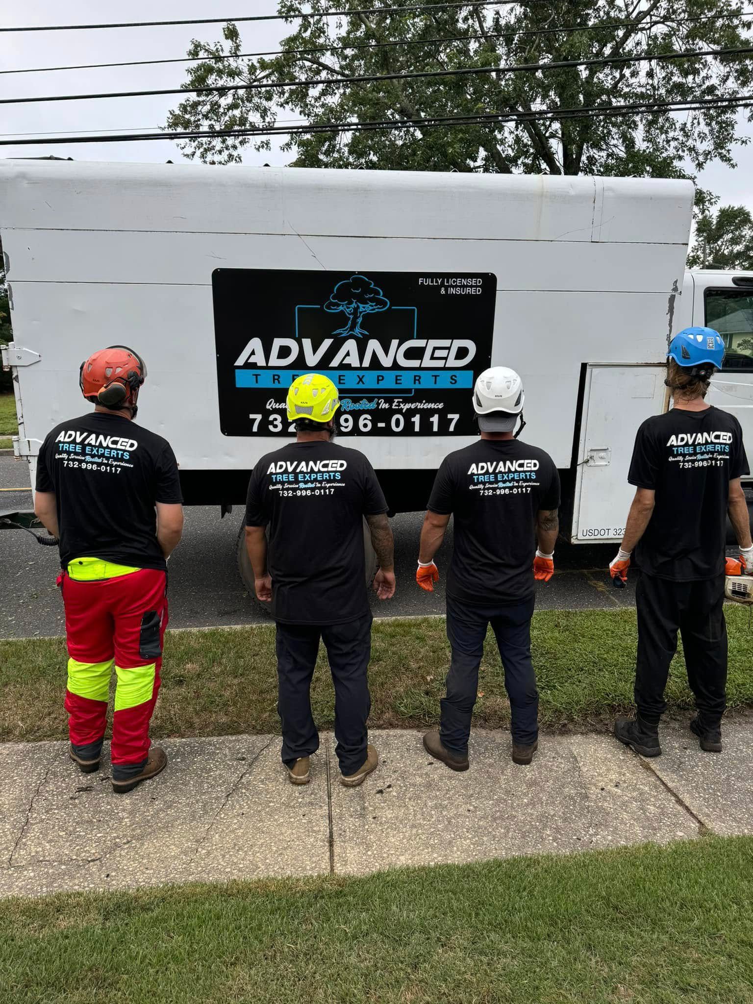 A group of men are standing in front of a white truck.