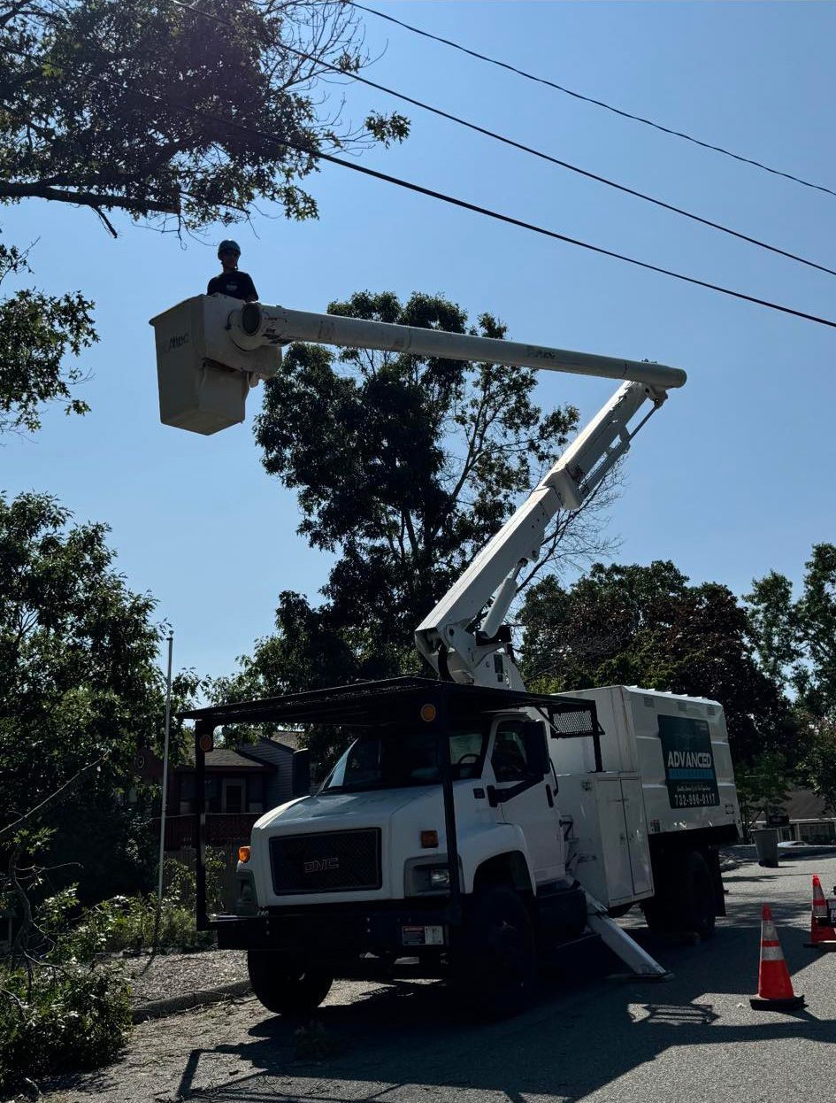 A man is sitting in a bucket on top of a truck.