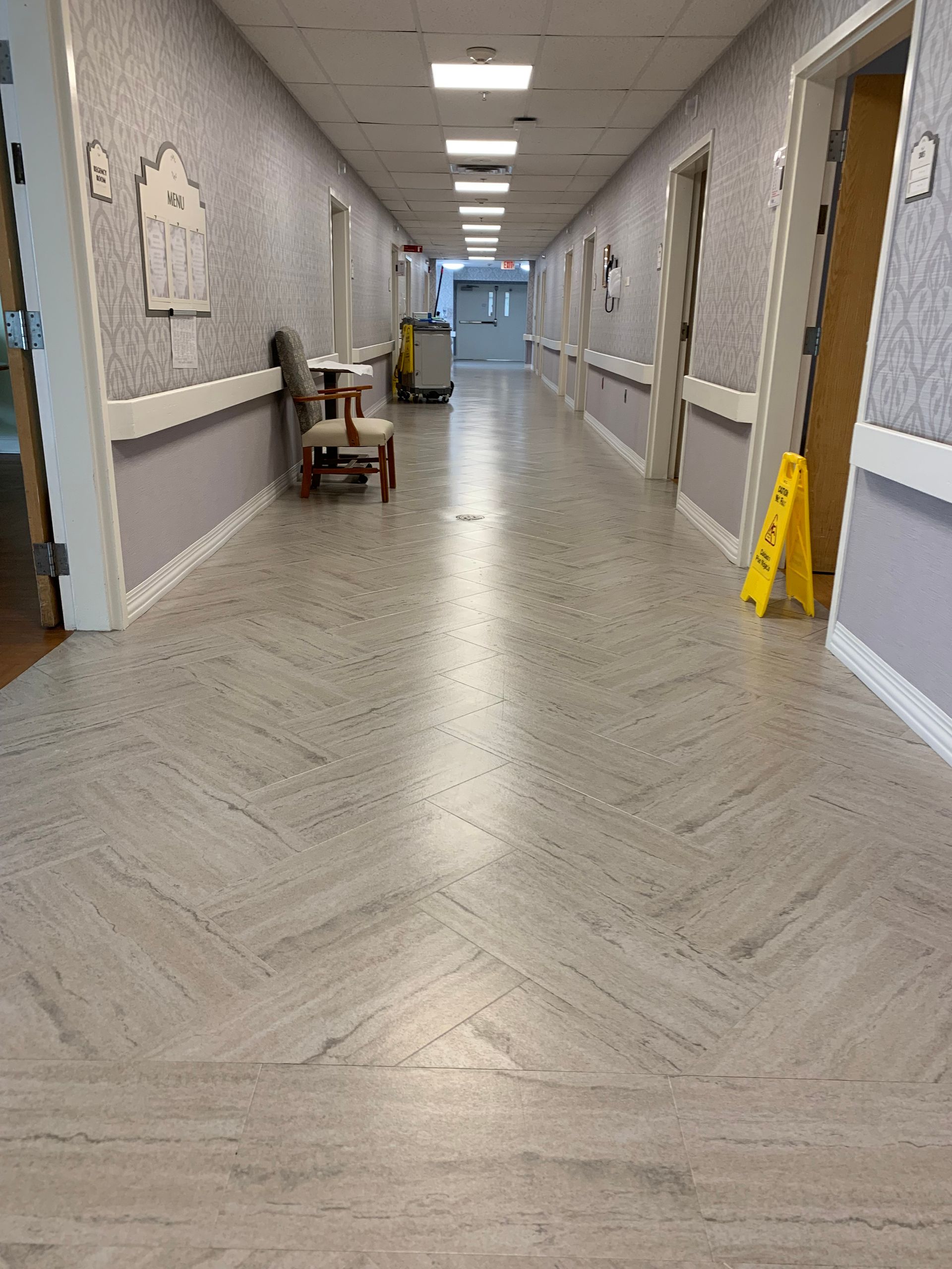 A long hallway with a yellow caution sign on the floor