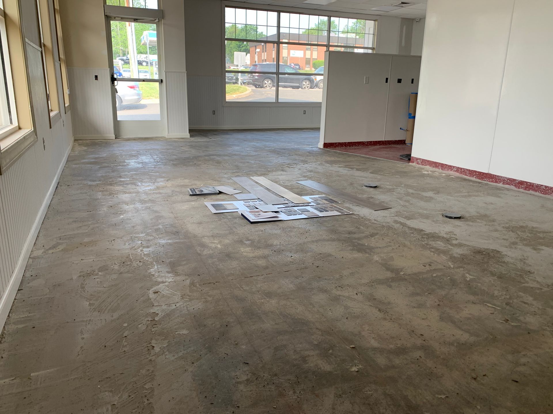 An empty room with a unfinished concrete floor and white walls