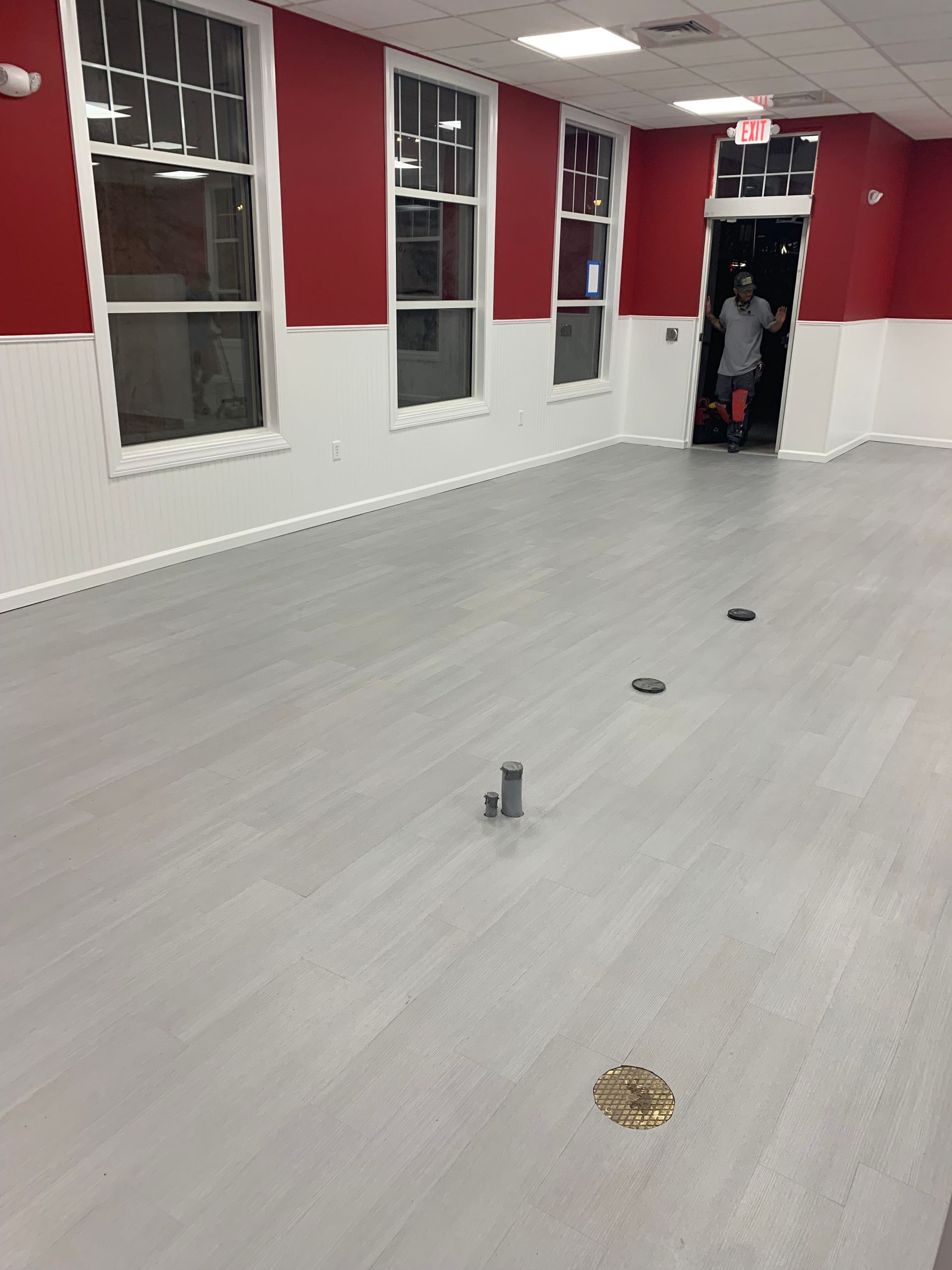 An empty room with red walls and white trim and new floor
