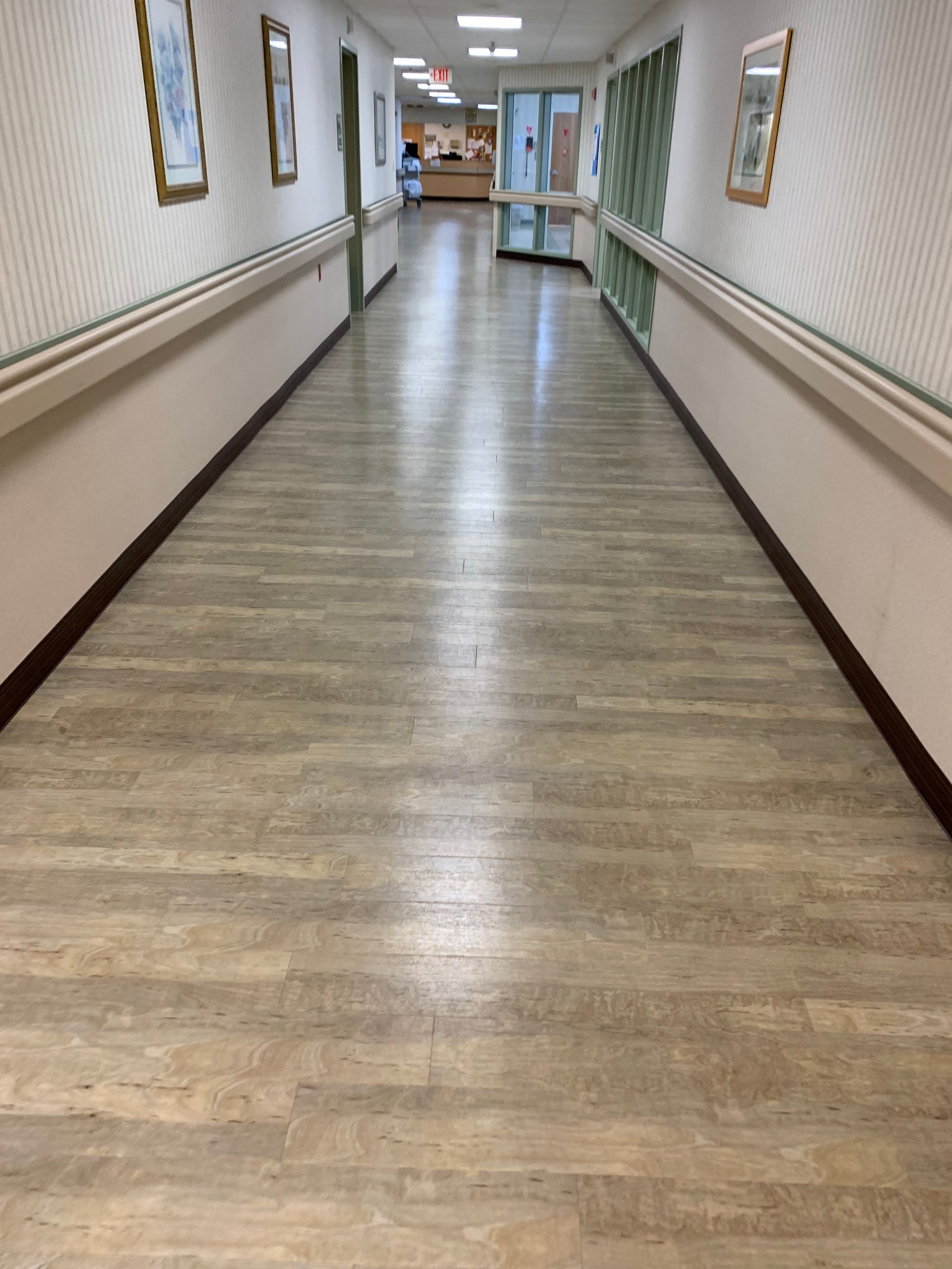A long hallway with wooden floors in a hospital