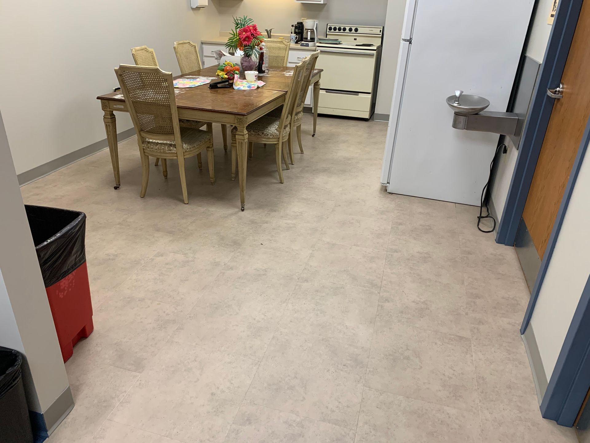 A dining room with a table and chairs and a water fountain