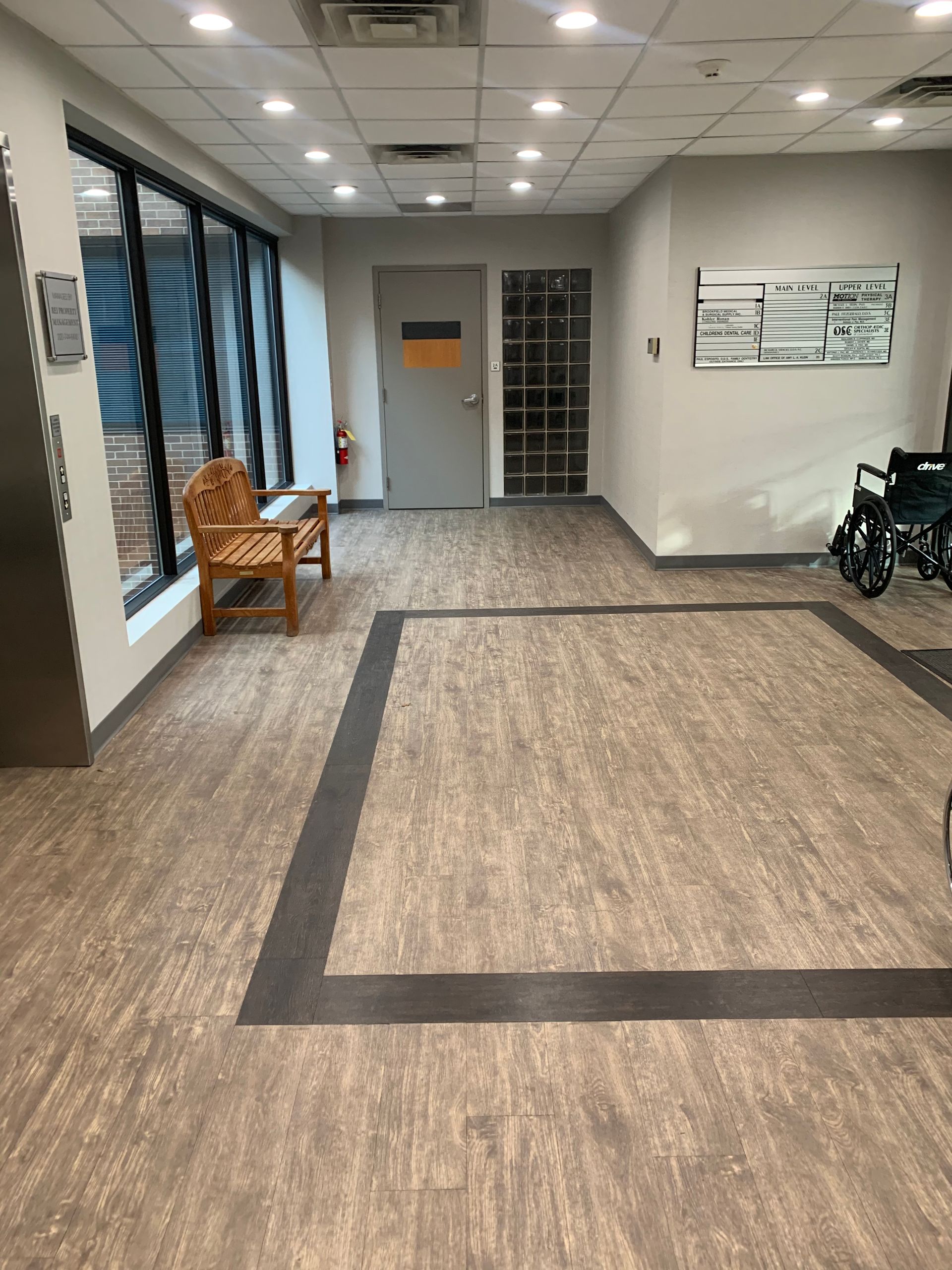 A hallway with a chair and a wheelchair in it