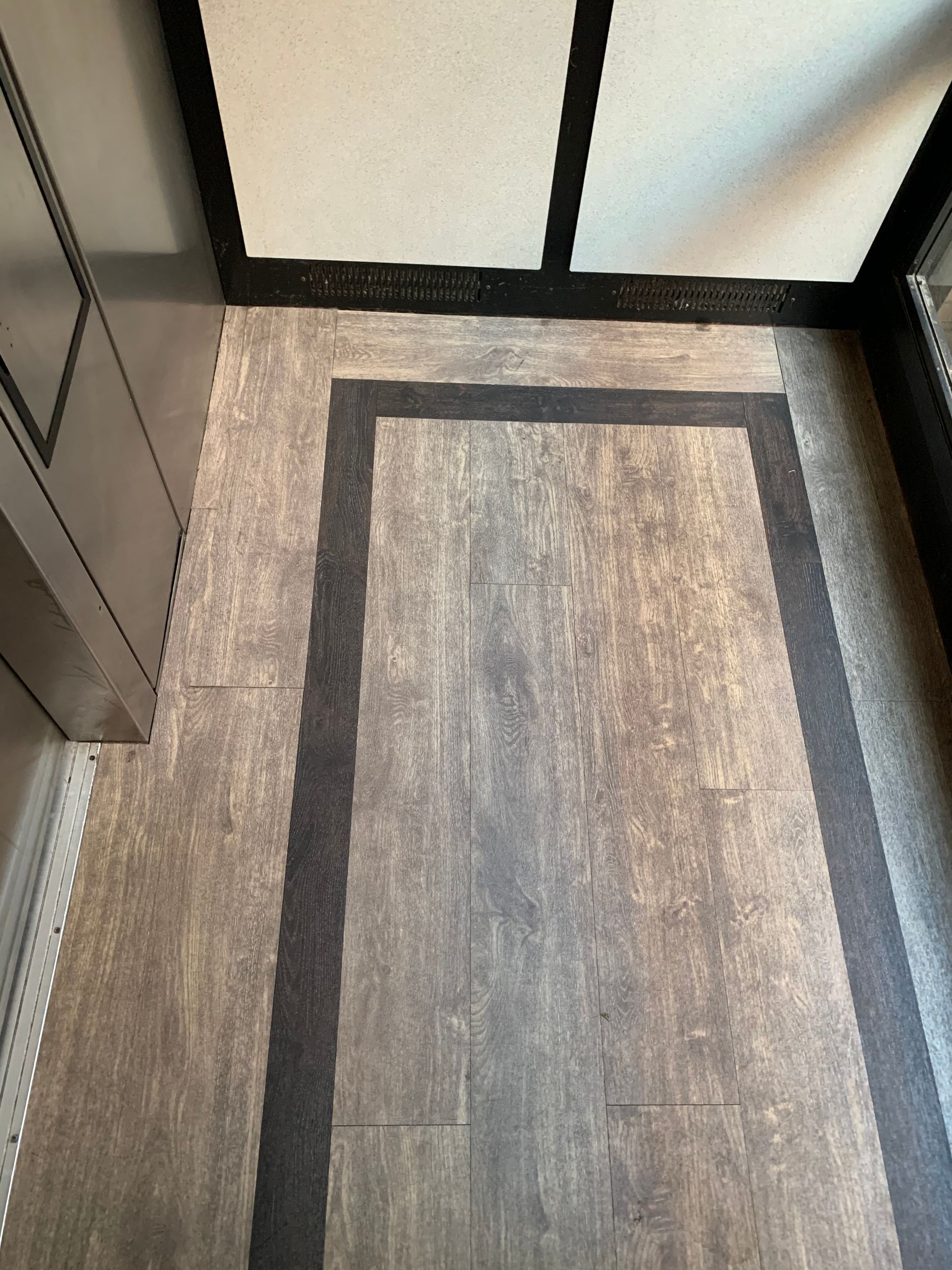 A close-up of a floor in an elevator with a black border