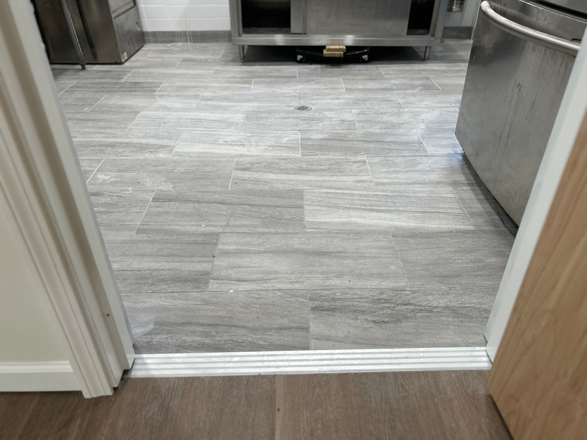 A doorway leading to a kitchen with a gray tile floor