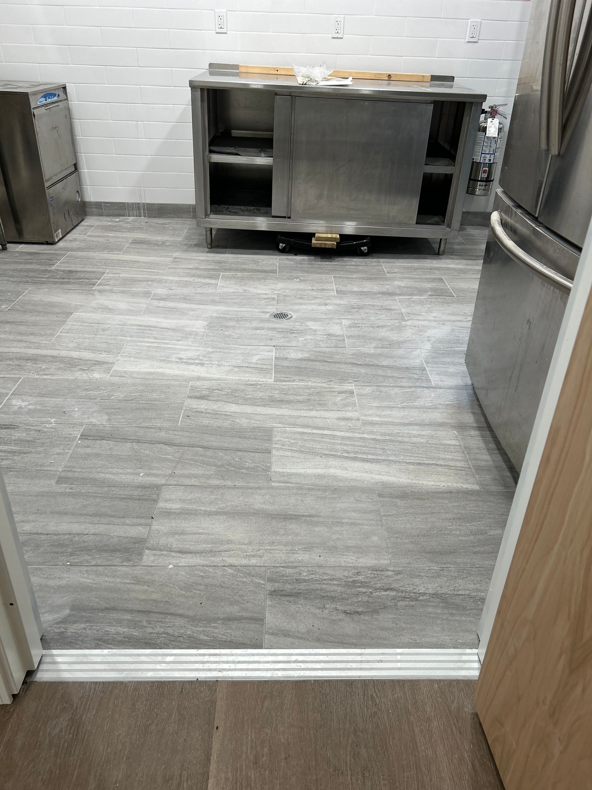 A kitchen with a stainless steel counter top and a refrigerator