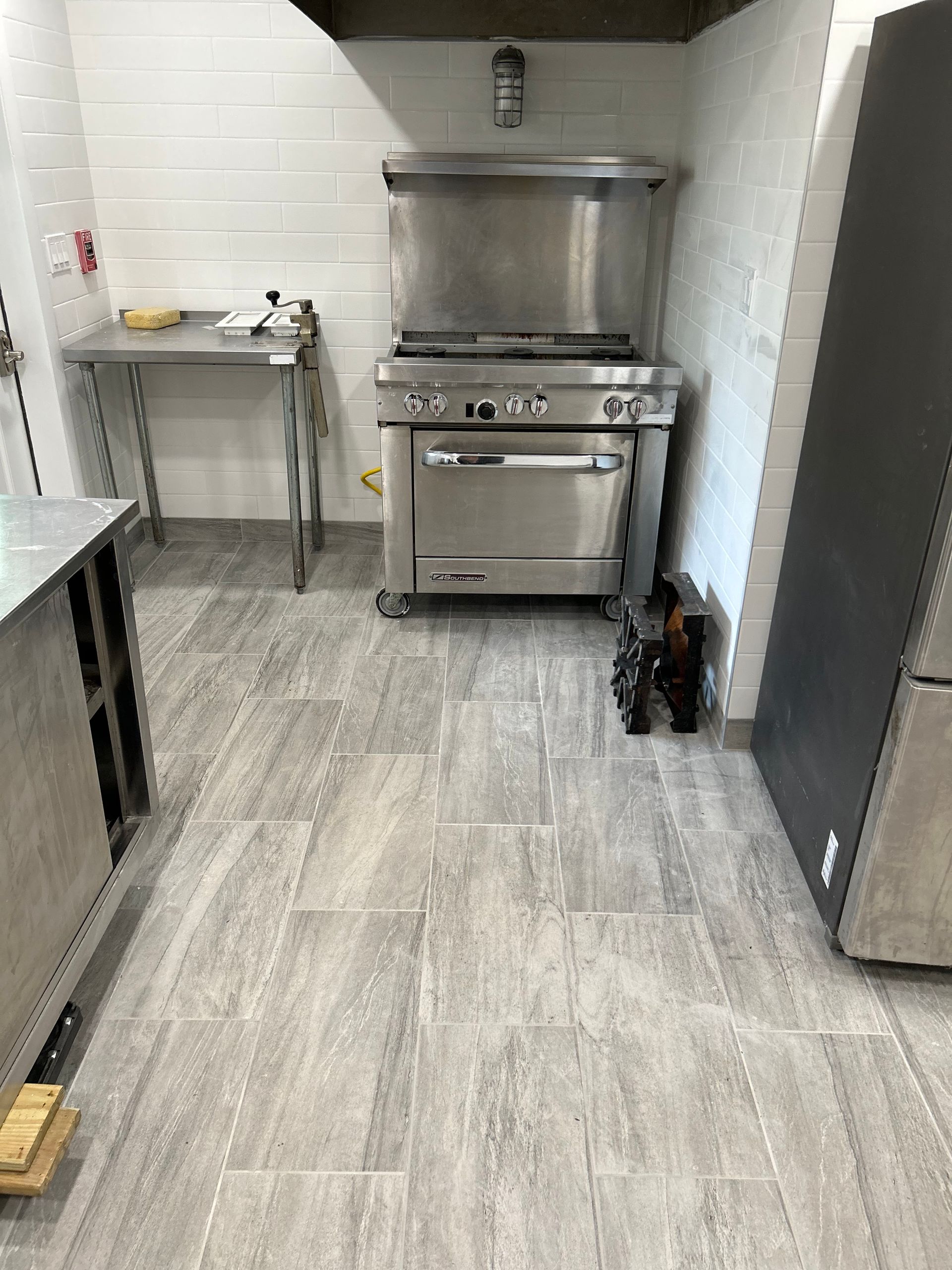 A kitchen with a stove and a refrigerator in it
