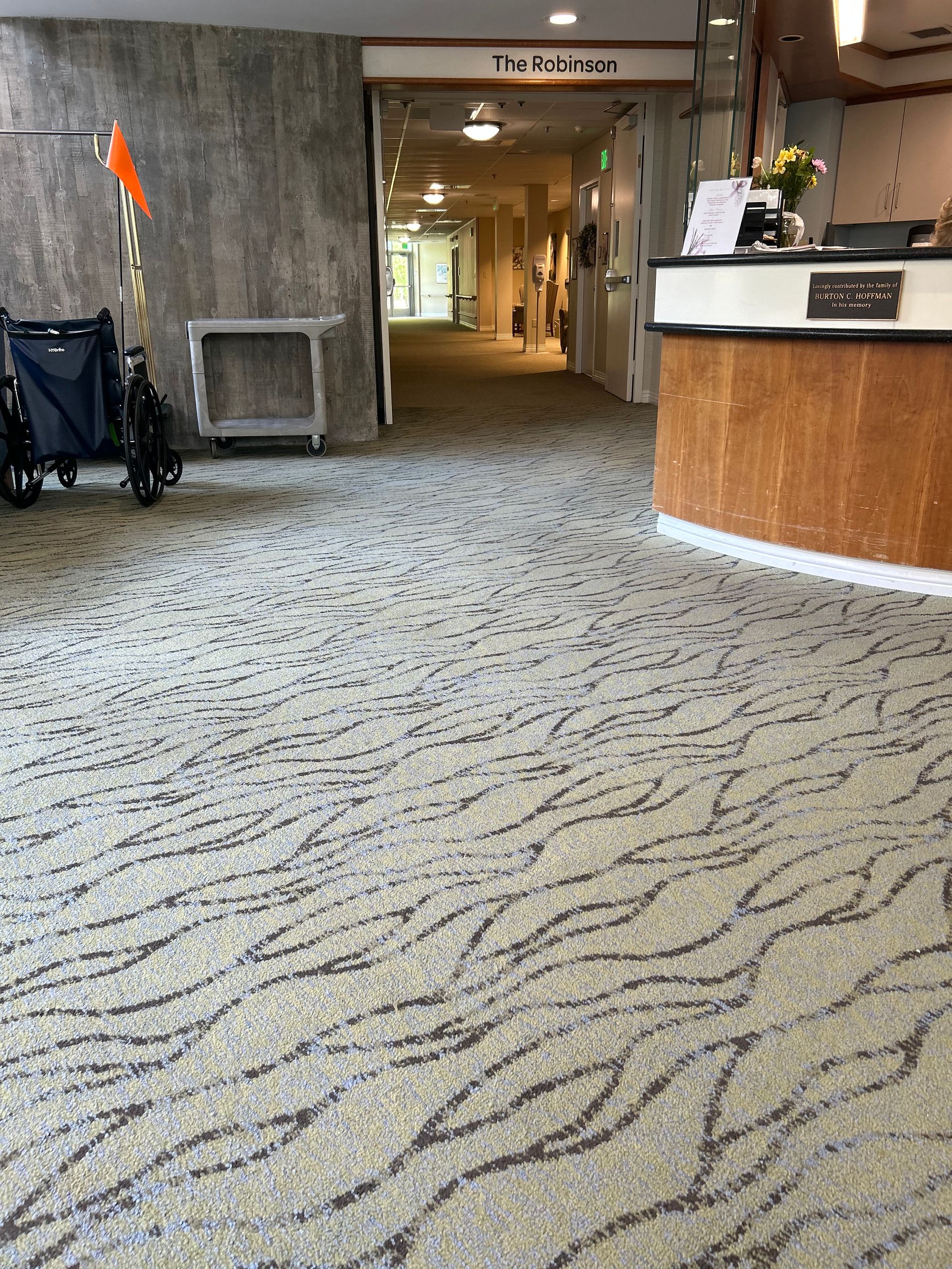 A wheelchair is parked in the hallway of a hospital