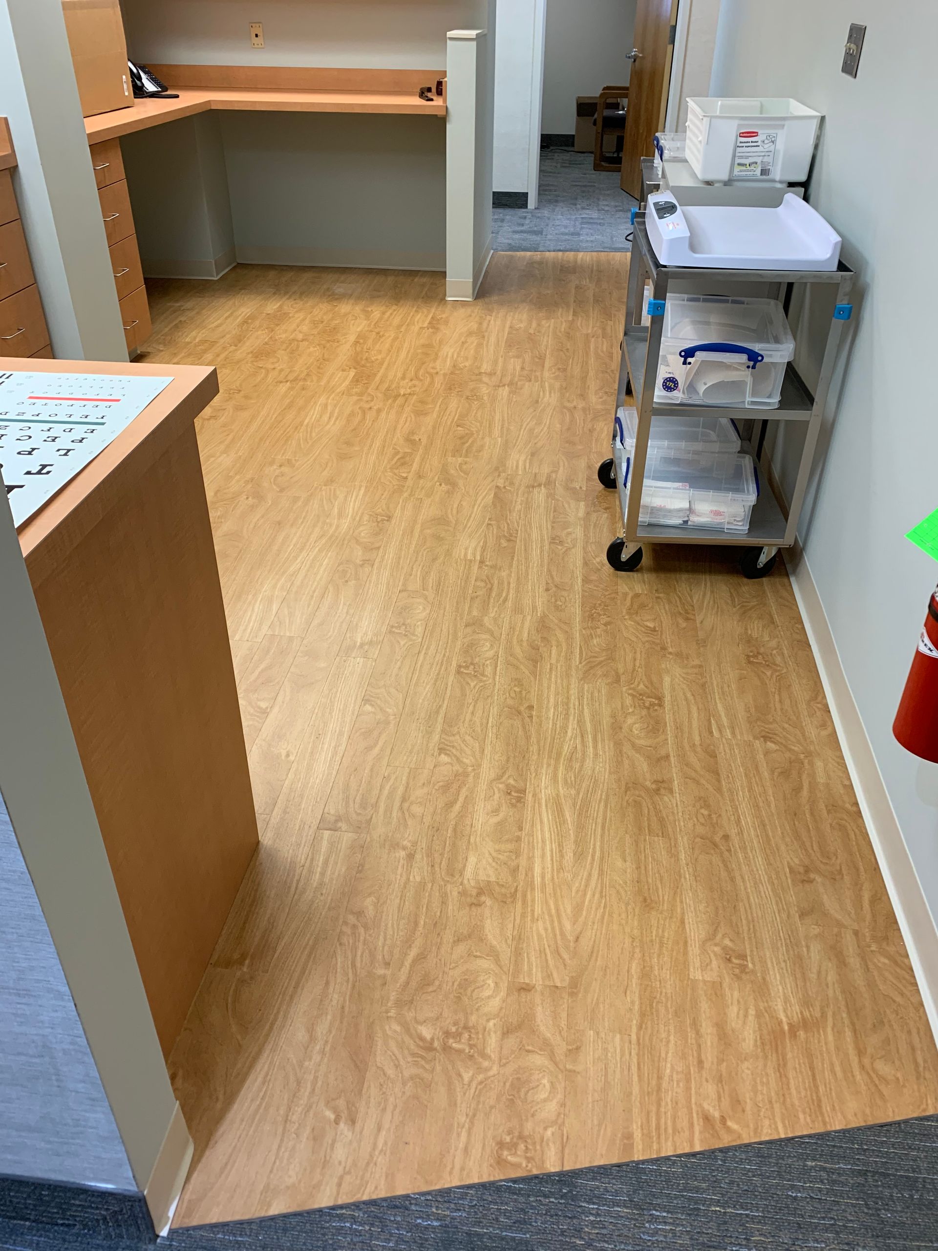A room with a wooden floor and a cart with boxes on it
