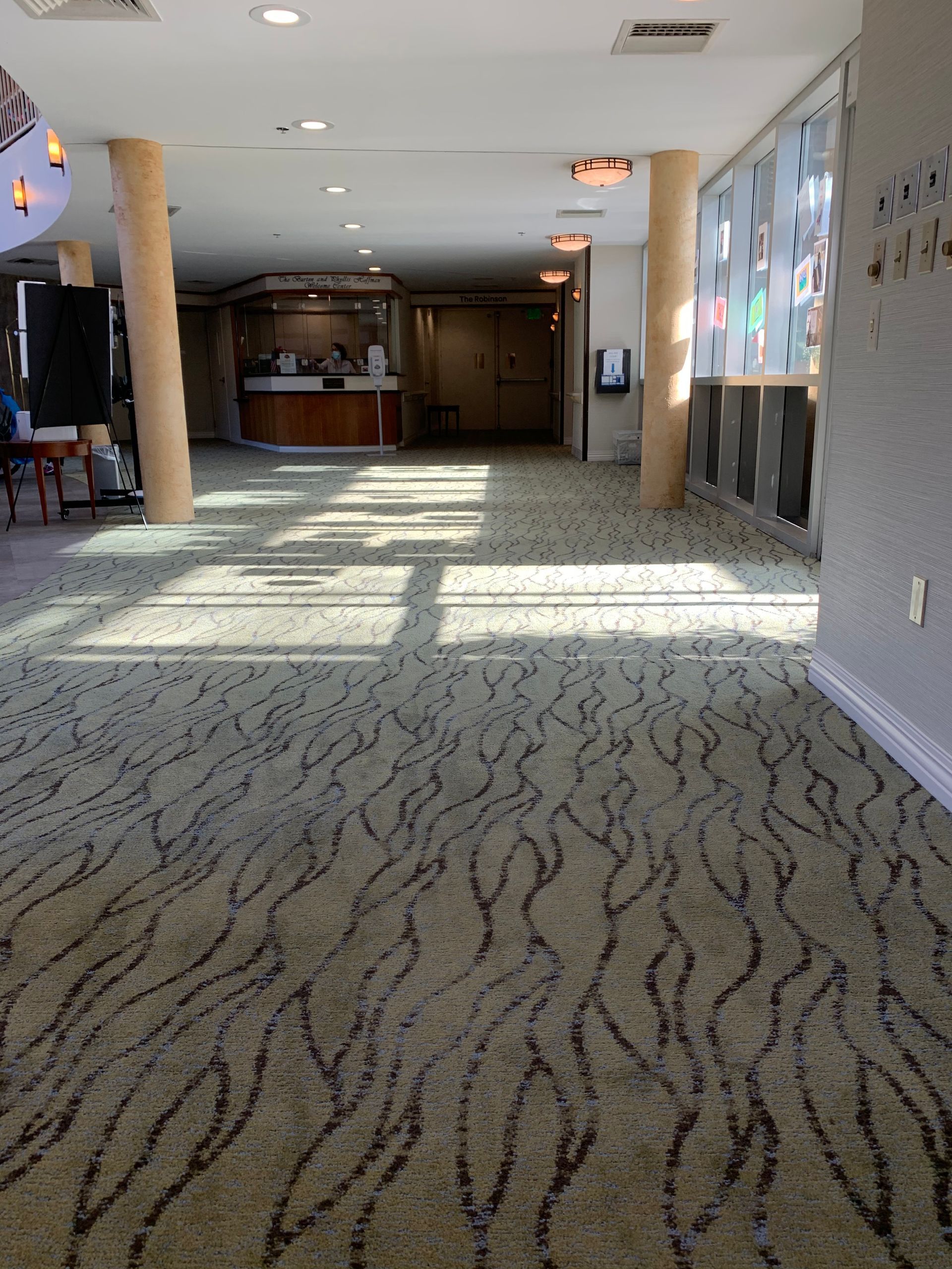 A large room with a carpeted floor and a reception desk