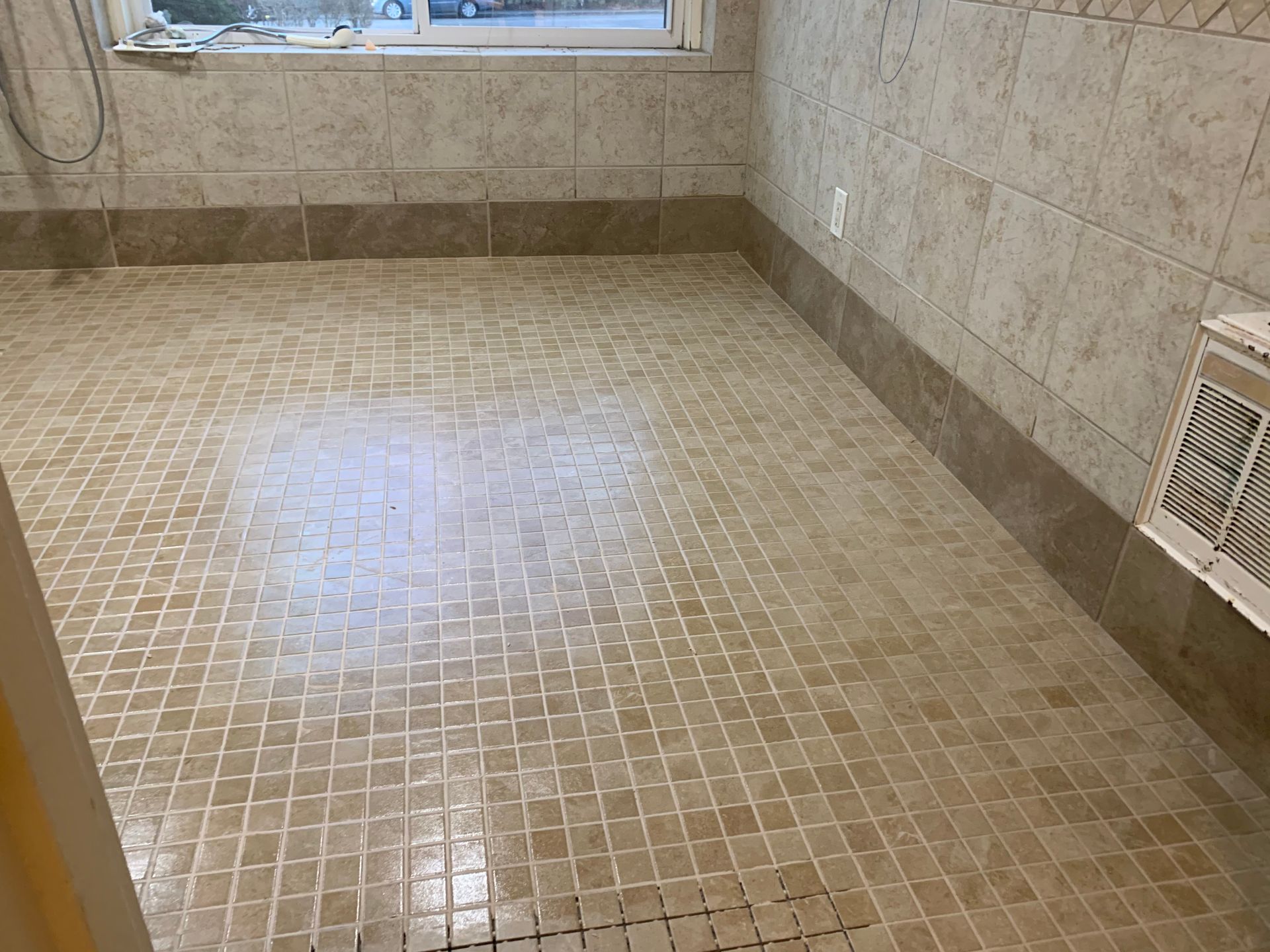 A bathroom with a tiled floor and a window
