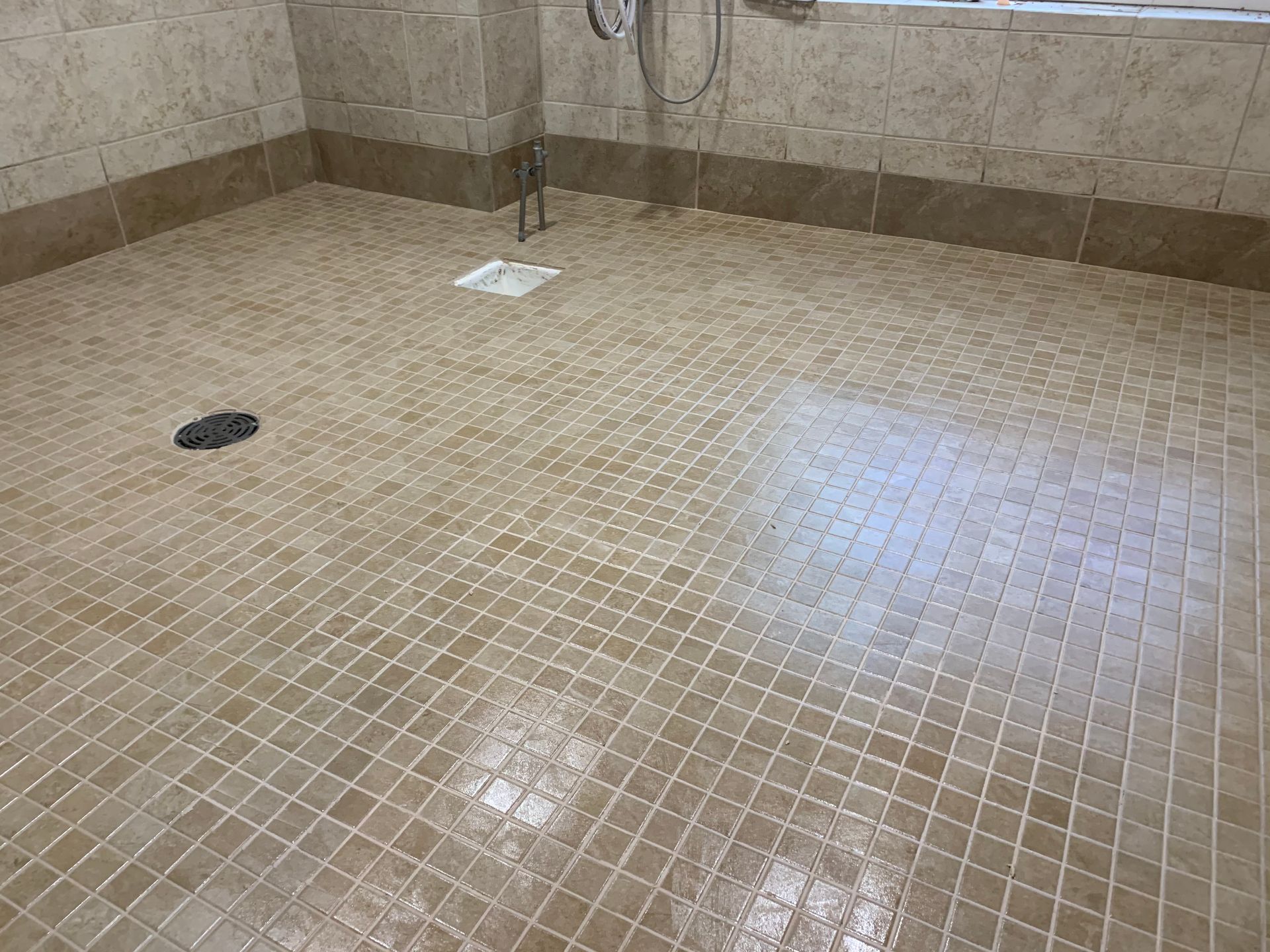 A bathroom with a tiled floor and a shower