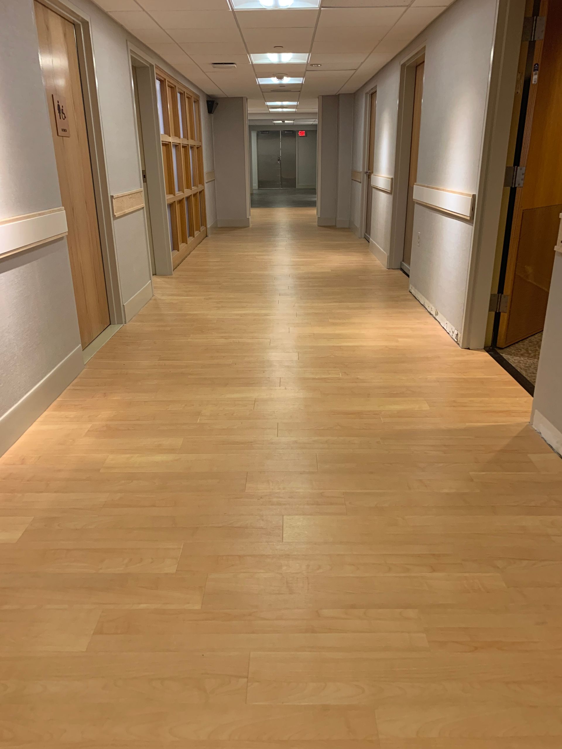 A long hallway with wooden floors in a building