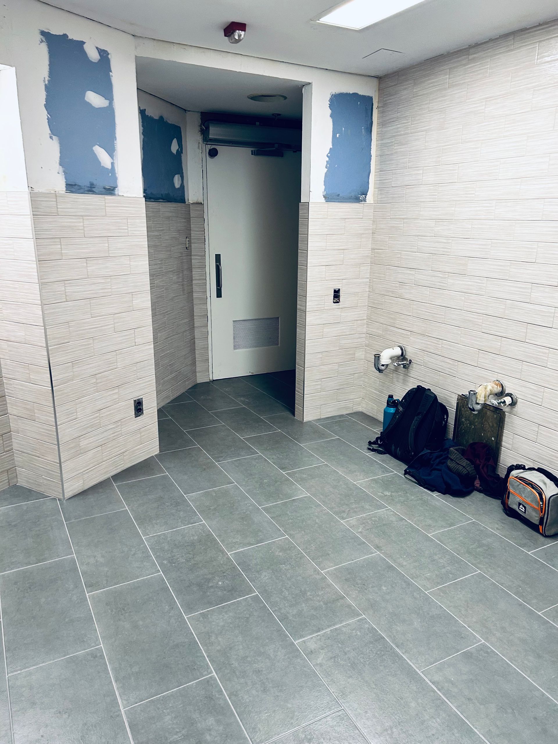 An empty room with a brick wall and a tiled floor