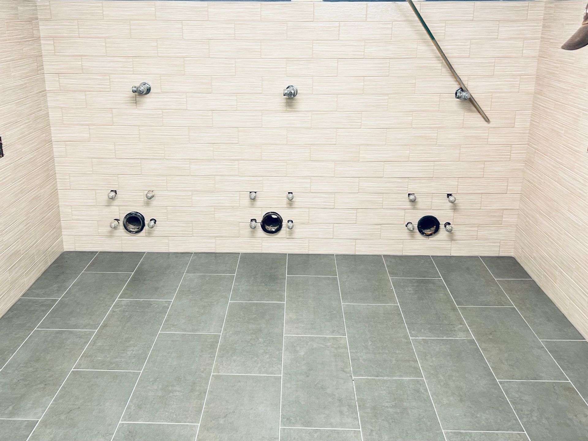 A bathroom with a tiled floor and a brick wall