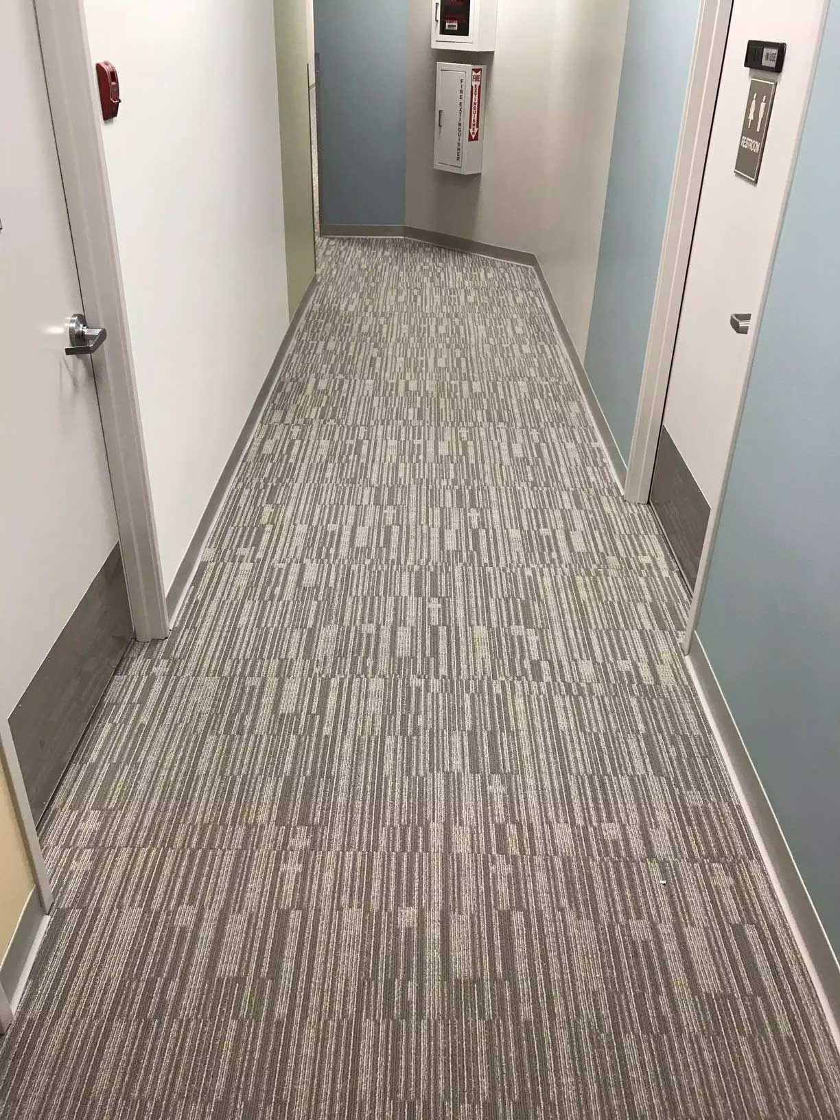 A long hallway with a carpeted floor and blue walls