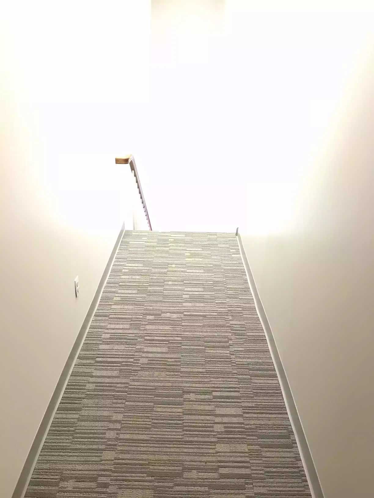 A carpeted hallway leading to the stairs