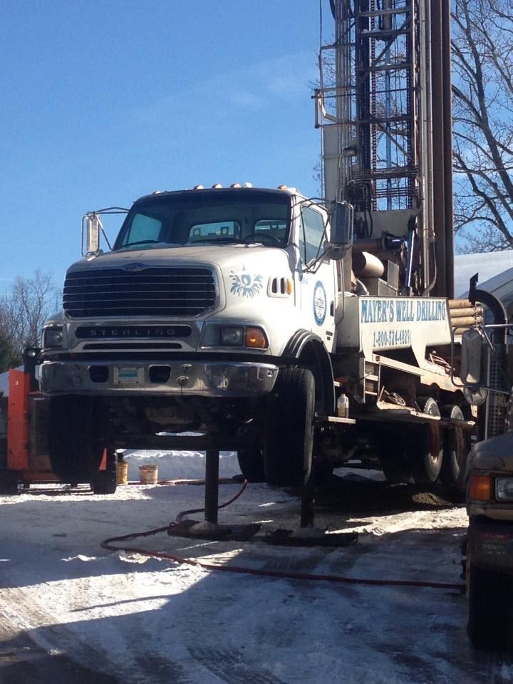 A white truck with a sign on the side that says ' water well '