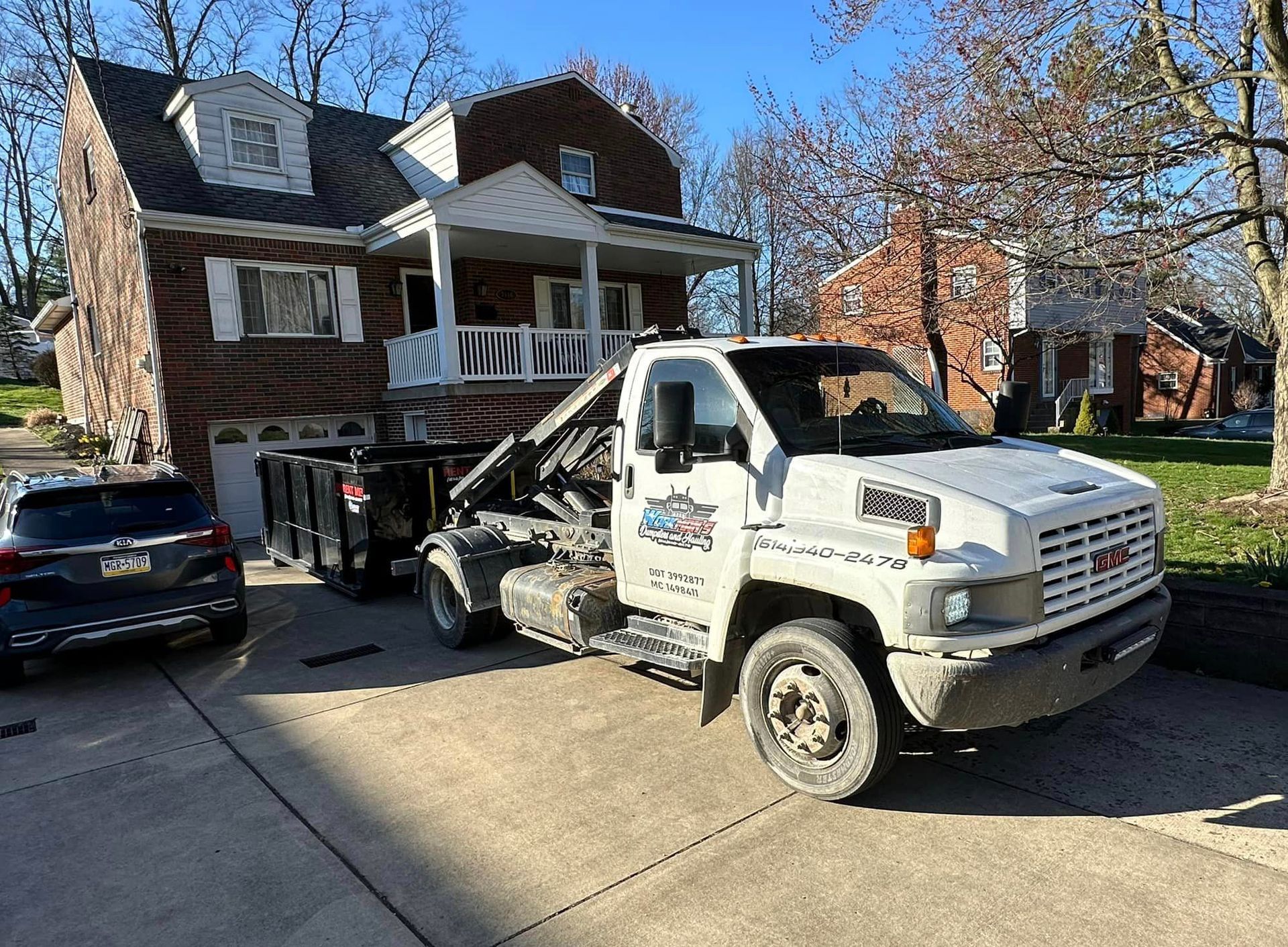 A white tow truck is parked in front of a house.